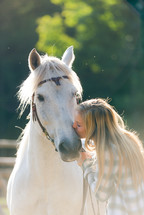 Woman kissing a horse.
