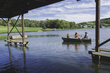 rowing in a fishing boat under a bridge 