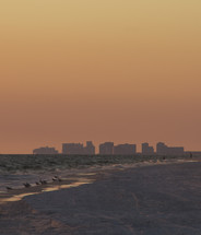 silhouettes of hotels along a beach shore 