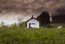 small white chapel under cloudy skies 