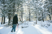 man walking through a snowy forest 