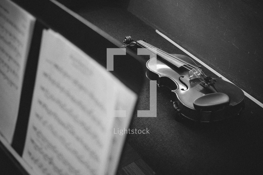 sheet music on a music stand and violin 
