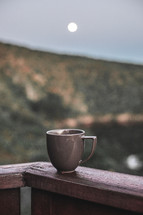 coffee mug on a railing 