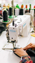 Woman sewing a zipper onto fabric with a sewing machine