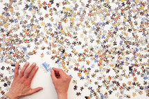 Point of view of a man assembling a jigsaw puzzle