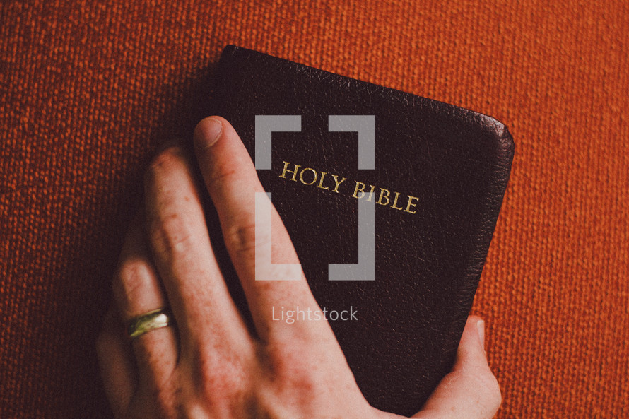 hand on a pocket Bible 