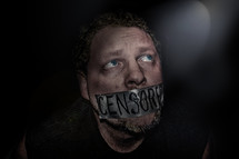 Man with duct tape on his mouth -- "censored."