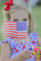 a little girl holding an American flag 