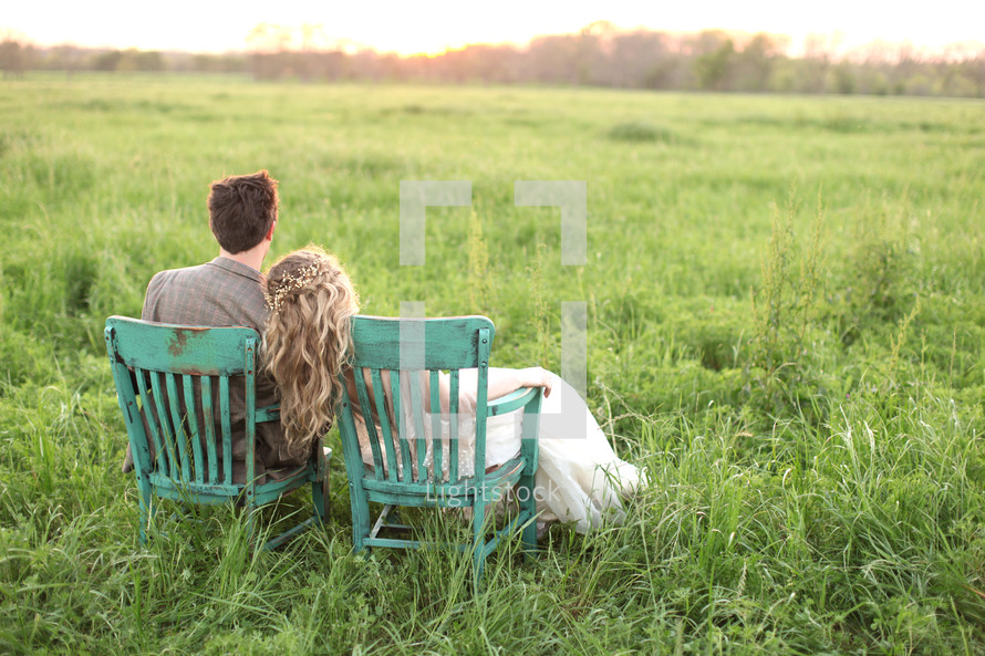 couple sitting in chairs outdoors in tall grass