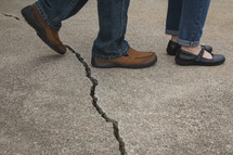 Husband stepping over a crack towards his wife
