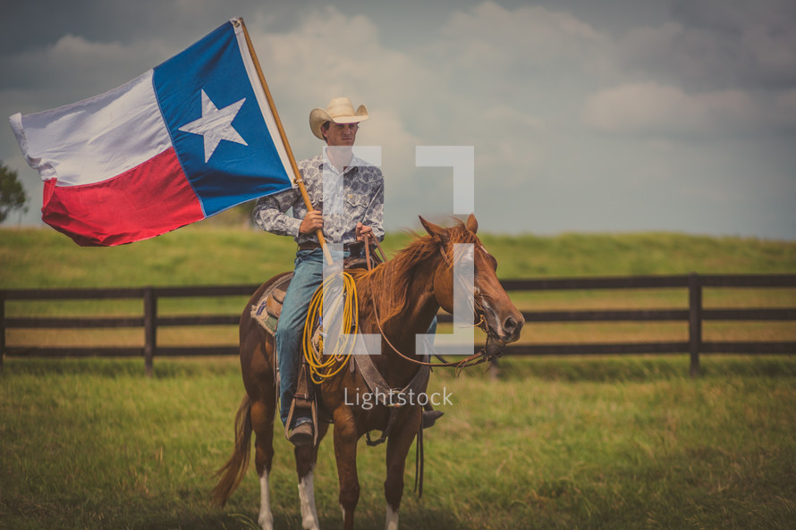 man riding a horse holding a Texas flag