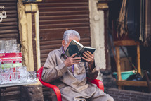 vendor reading a book at an outdoor market in Egypt 