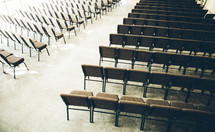 church nave between empty rows of chairs 