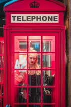 a young woman in a telephone booth 