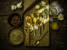 Spoons with spices on wooden table