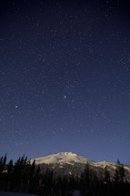 stars over an icy mountain peak