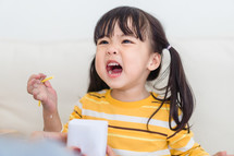 toddler girl eating a snack 