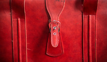 a strap on a red suitcase 