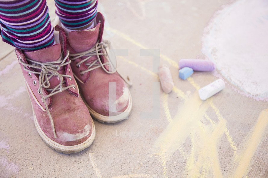 a child and sidewalk chalk 
