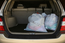 bags of clothes to donate in the back of an SUV