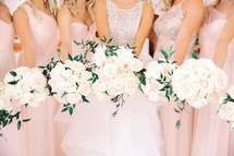 brides and bridesmaids holding bouquets 