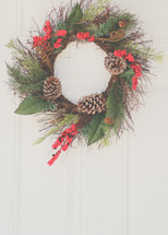 a Christmas wreath hanging on a door 