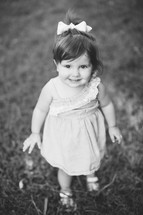 toddler girl standing in grass