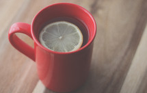 lemon in tea in a red mug 