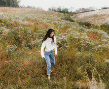 young woman standing in a field 