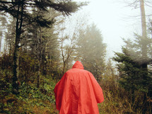 a man in a rain poncho in a forest 