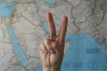peace sign in front of a map of the Middle East