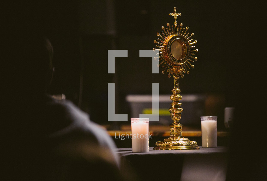 People praying before a Catholic monstrance in Eucharistic adoration 
