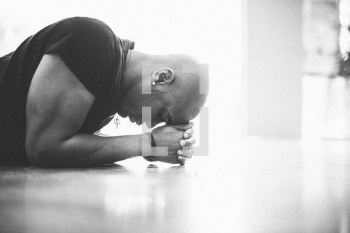 Man with head on hands praying on the floor. — Photo — Lightstock