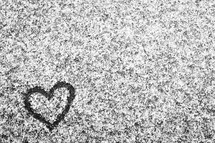 heart drawn in the snow on pavement 