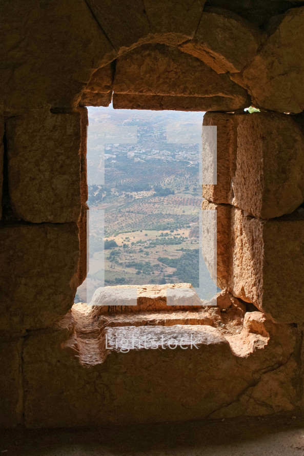 view of a hillside through a window in ruins in Jordan 