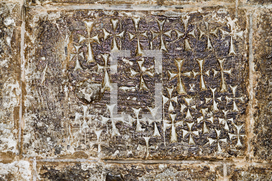 Crosses etched into the stone wall inside of the Church of the Holy Sepulchre.