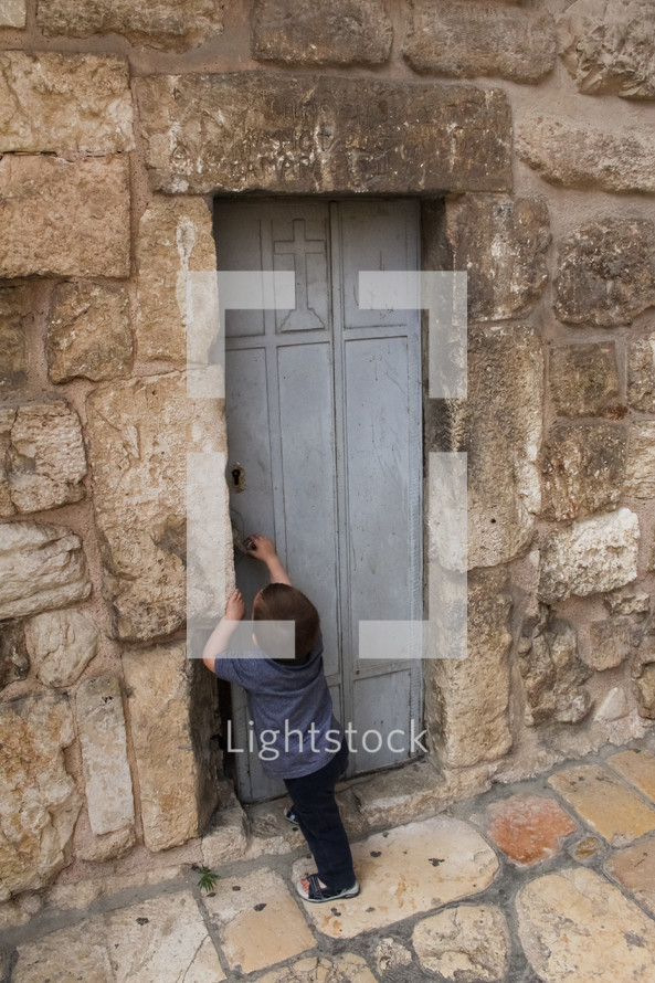 a boy at the entrance of an ancient door 