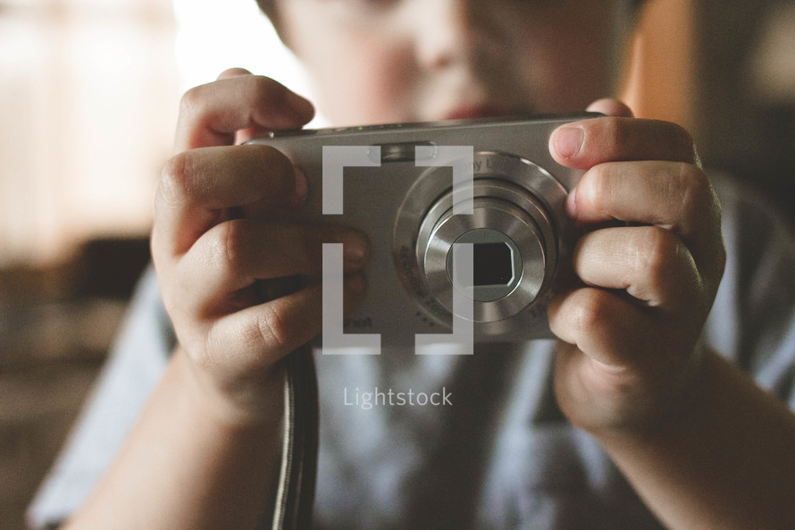 Child holding a digital camera.
