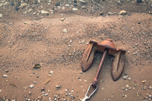 rusty anchor lying on the shore