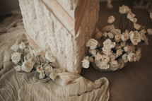 small white flowers near a marble pillar