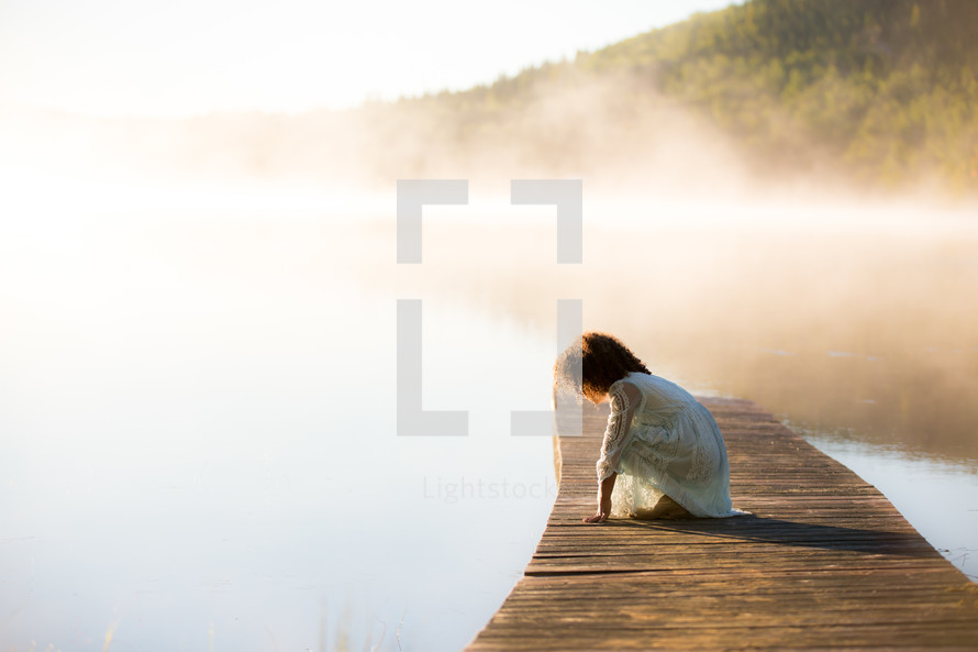 a girl on a dock over a steaming lake 
