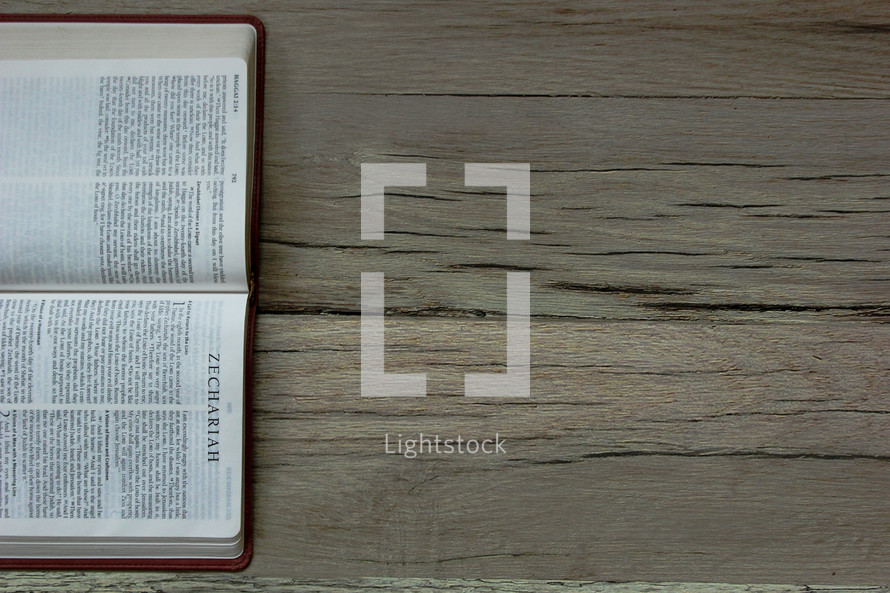 Hebrew Bible open to the Book of Zechariah on a wooden floor.