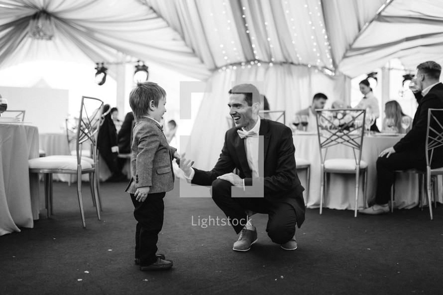 a groom talking to a child at a wedding 