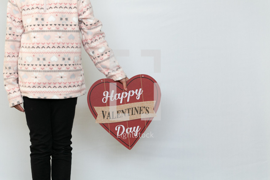 A child holding a Happy Valentine's day sign 