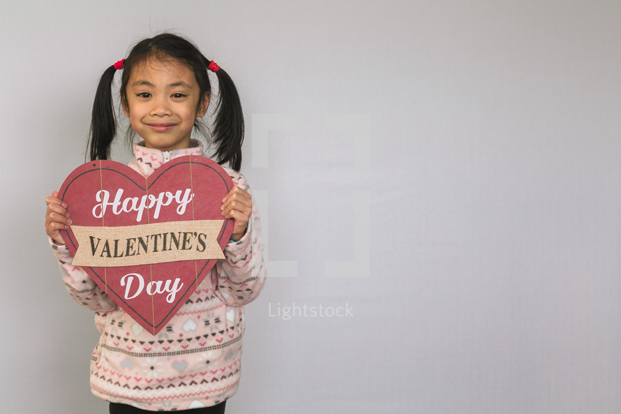 A child holding a Happy Valentine's day sign 