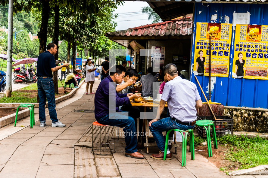 men eating lunch outdoors in China 