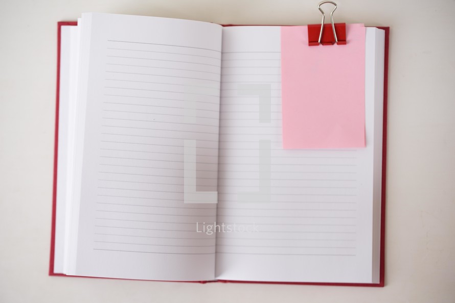 open journal, clip, and pink paper