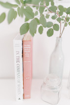 twig in a vase and books 