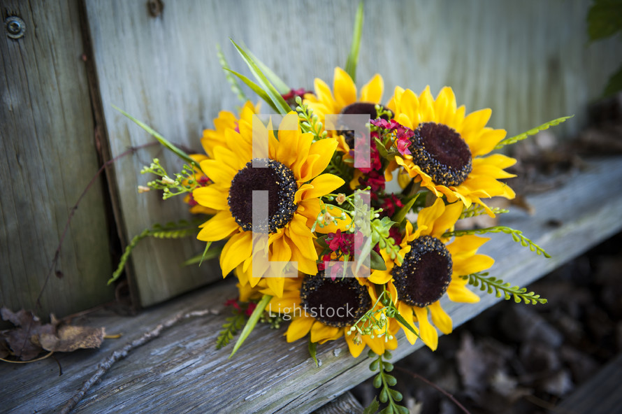 sunflower bouquet on a wood fence 