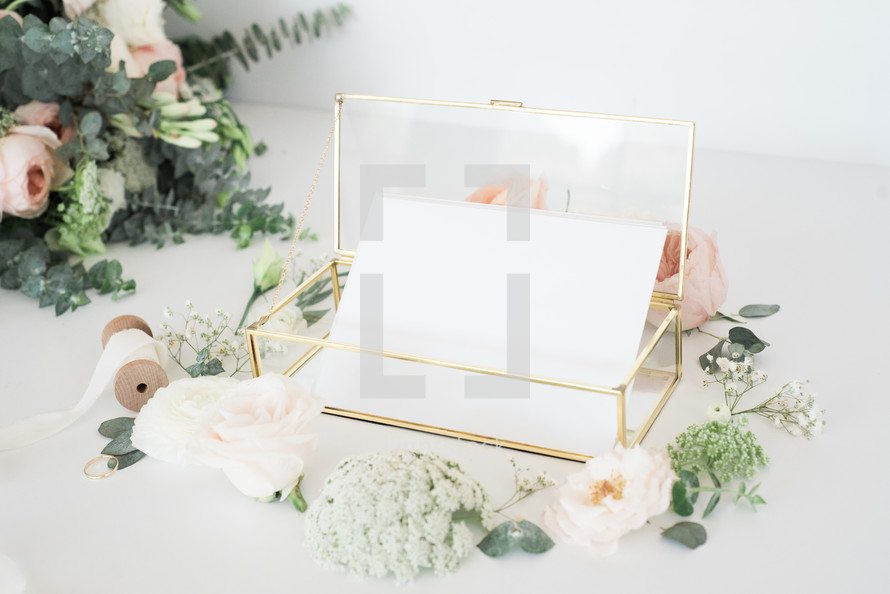 glass box with stationary and a border of roses 